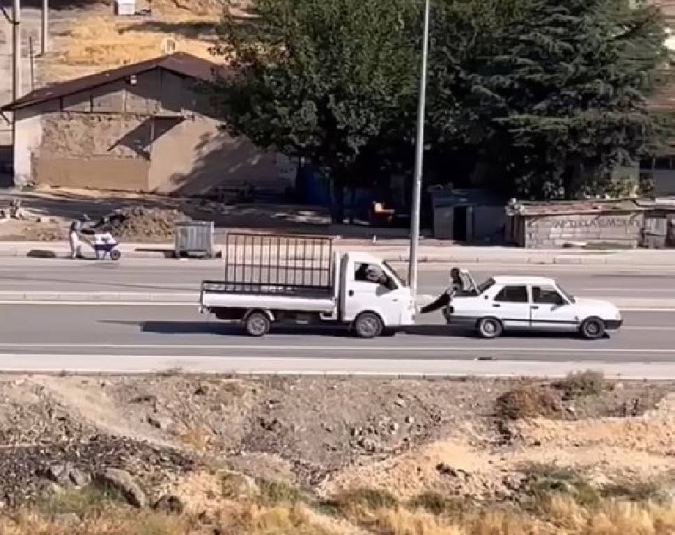 Elazığ'da yolda kalan aracı ayaklarıyla itti